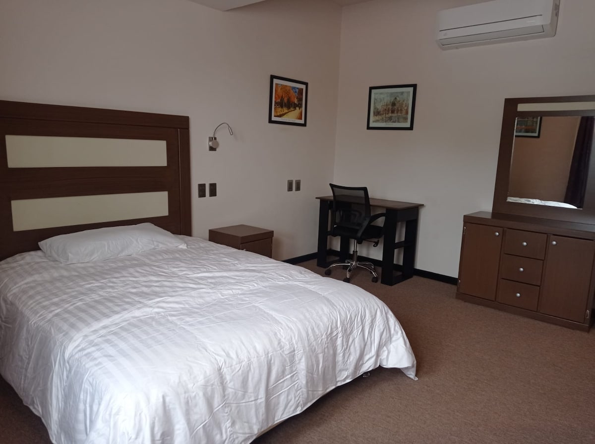 Стая с работен кът, килер, смарт телевизор и климатик.