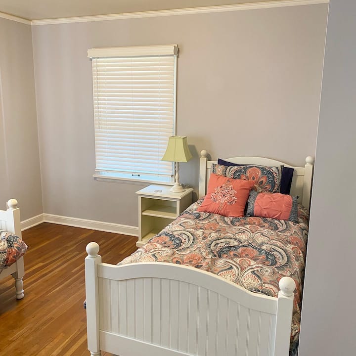 Spavaća soba s 2 odvojena kreveta na prvom katu uključuje stolove, punjače za telefon, komodu, vješalice, stalak za prtljagu i dodatnu posteljinu.