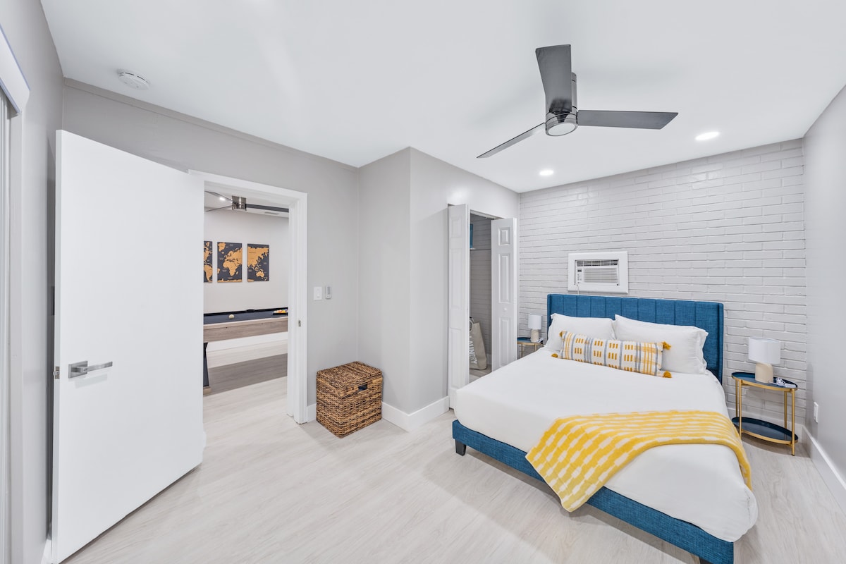 غرفة فلوريدا مع سرير كبير، طاولات ليلية، مصابيح مع دخول مباشر إلى حمام السباحة.  يرجى ملاحظة أن هذه الوحدة تحتوي على وحدة تكييف منفصلة كما تمت إضافتها بعد بناء المنزل الرئيسي.  يتم تخزين مناشف حمام السباحة المخططة في الكابانا في الغرفة في السلة المنسوجة.