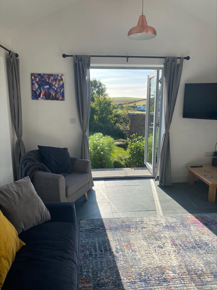 Salónik orientovaný na západ, dvere na terasu a veľkú záhradu