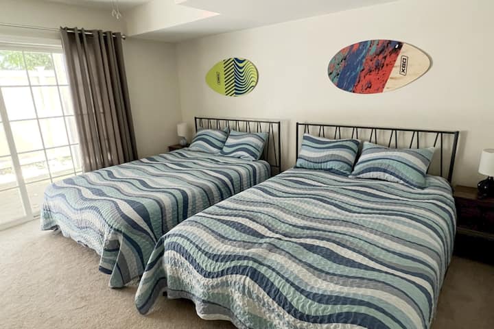 غرفة موجة بالطابق السفلي تضم سريرين كوين