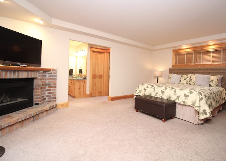 Chumba kikuu cha kulala kilicho na bafu, mahali pa kuotea moto na runinga janja.