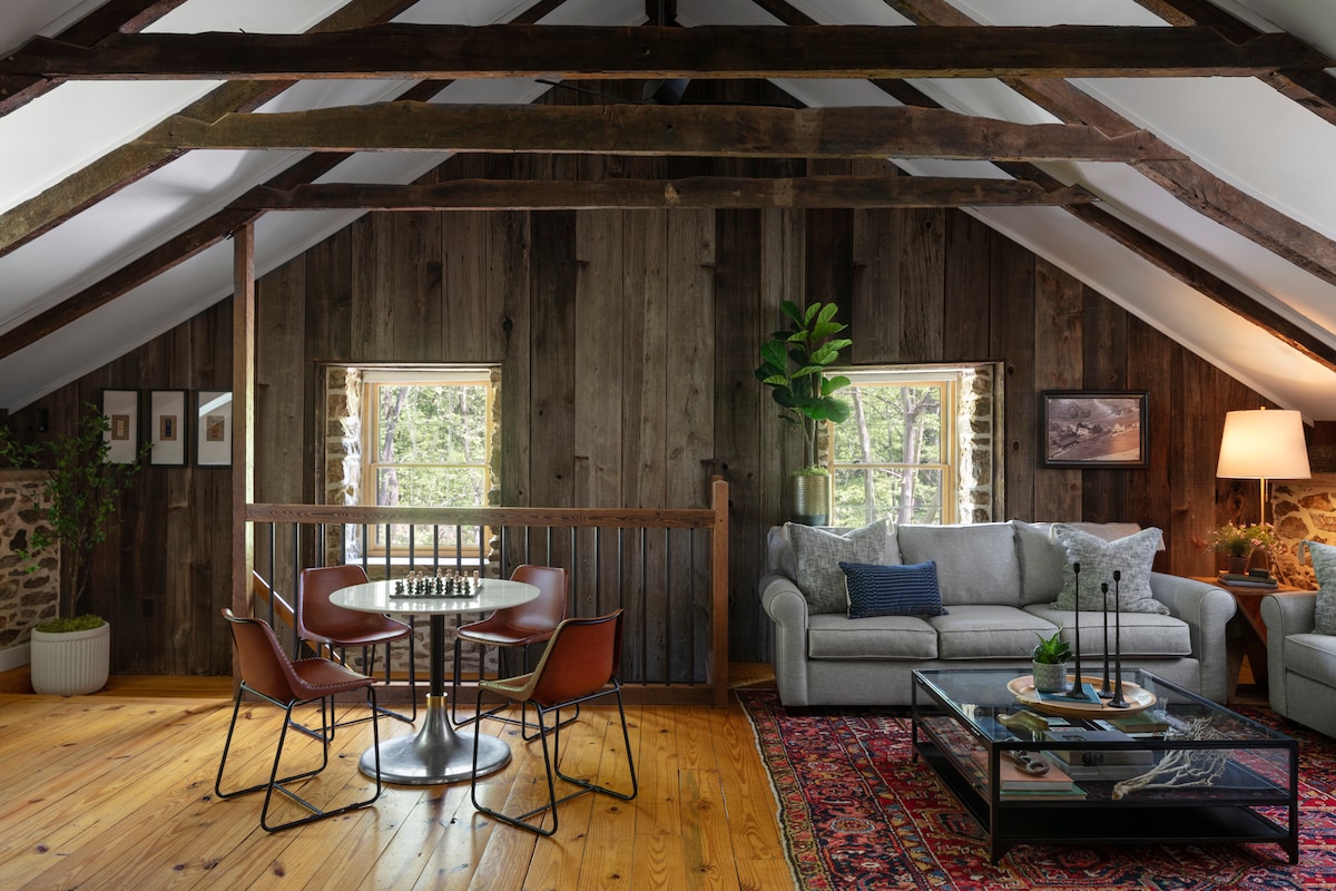 Enjoy the rustic charm of the upstairs living room, complete with reclaimed barnwood walls, exposed ceiling beams, and a game table.  