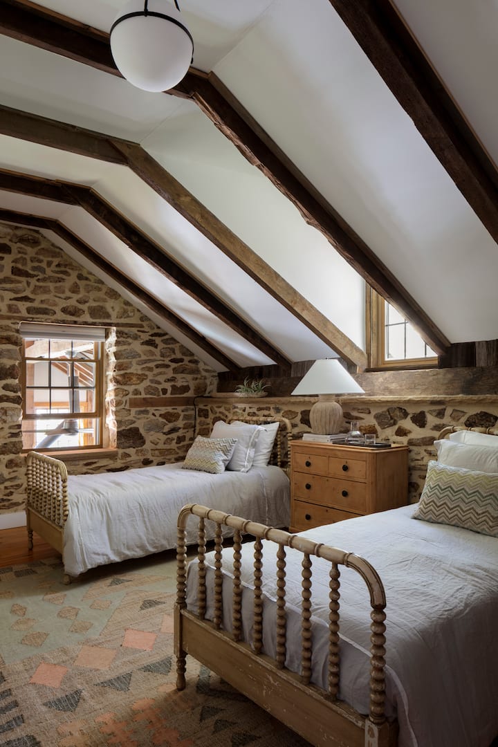 إطلالة أخرى على غرفة الضيوف المزدوجة في الطابق العلوي مع سجادة أنثروبولوجية مريحة ونافذة خلابة تطل على غرفة الشمس أدناه.  هنا يمكنك الاسترخاء بأناقة وراحة!