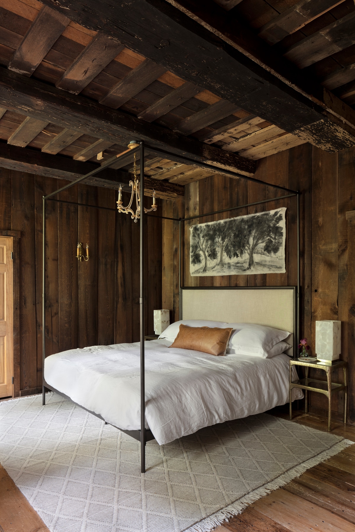 Distillery House - The stunning and moody first floor primary suite. Featuring a majestic Restoration Hardware king size canopy bed, an exquisite painted tapestry, and a designer chandelier, this room exudes sophistication and style.  