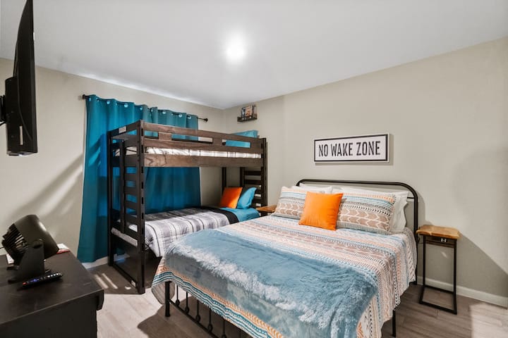 Sekundárna spálňa pre 4 osoby! Posteľ veľkosti Queen má pohodlný matrac z pamäťovej peny. Inteligentná televízia a zatemňovacie závesy v miestnosti. Detské knihy v poličke nad hornou poschodovou posteľou a hry v televíznej konzole.