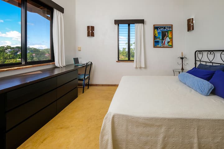 King bed with door in the bedroom that opens into the bathroom.