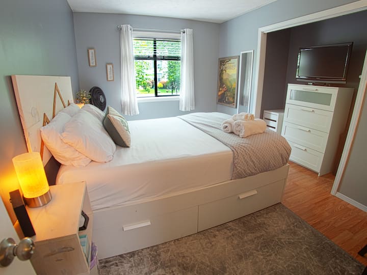 Queen Bedroom/Work Space: This bright, airy room offers a queen bed, Roku TV, and a dedicated workspace for those who need to stay connected.