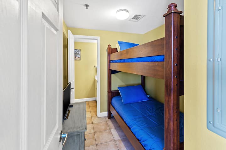 La habitación litera tiene camas individuales y medio baño privado.  La televisión inteligente tiene una caja Roku.