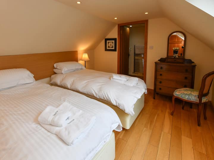 غرفة النوم الأولى بسريرين مفردين، يمكن أن تتكون من سرير بمقاس كينغ فائق عند الطلب. غرفة استحمام داخلية ومساحة تخزين معلقة وأدراج ونوافذ فيلوكس وطاولات بجانب السرير مع مصابيح 