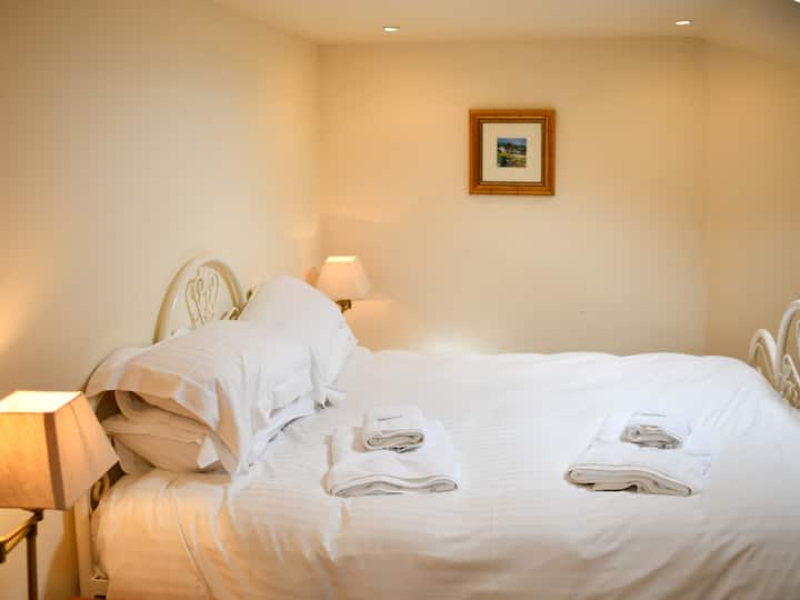 غرفة النوم الثانية، سرير بمقاس كبير، طاولة ملابس، مخزن معلق، طاولات بجانب السرير مع مصابيح، نافذة فيلوكس وغرفة استحمام داخلية 