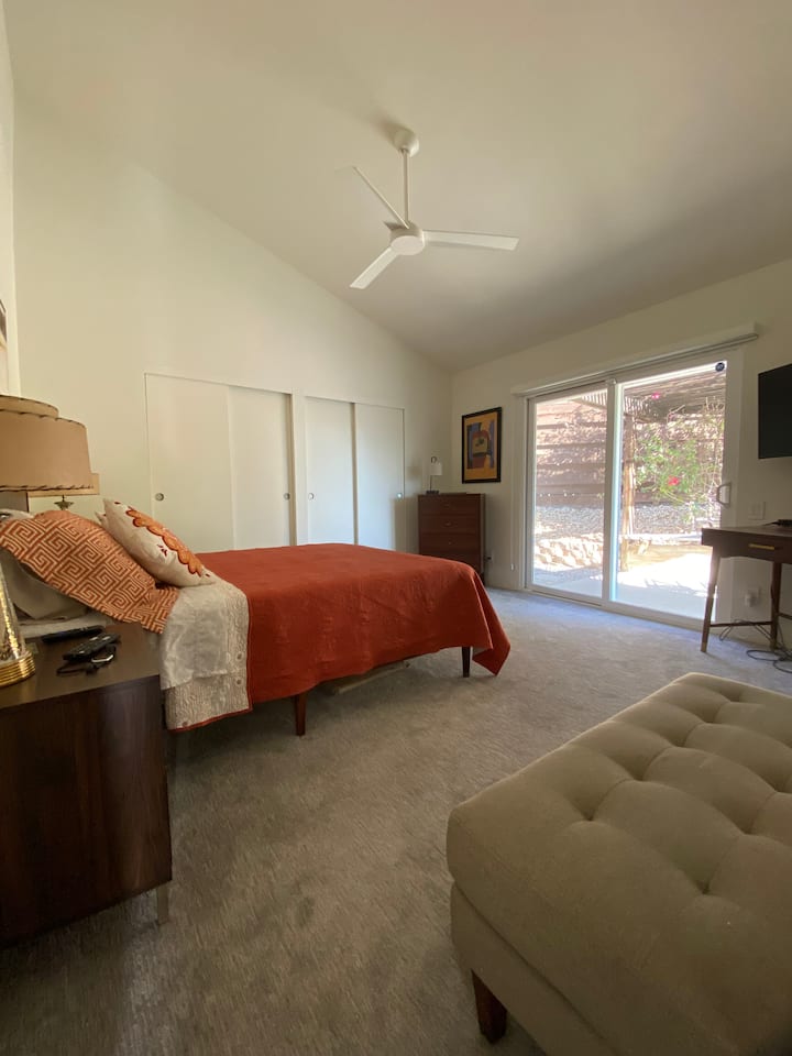 חדר שינה ראשי עם מיטת קווין סייז ופטיו פרטי