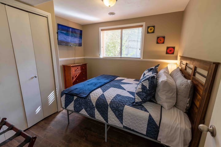 ห้องนอนเตียงควีนไซส์ชั้นล่างพร้อมสมาร์ททีวีและตู้เสื้อผ้า 