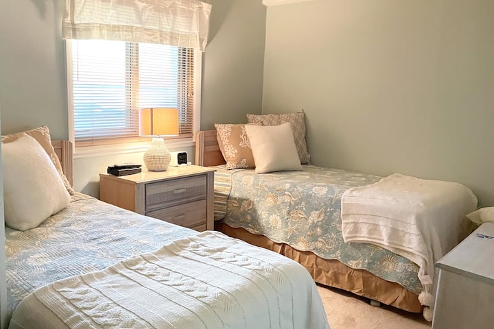 Dhoma e gjumit e dytë me dy krevate dyshe, ventilator tavani dhe pamje nga gjiri