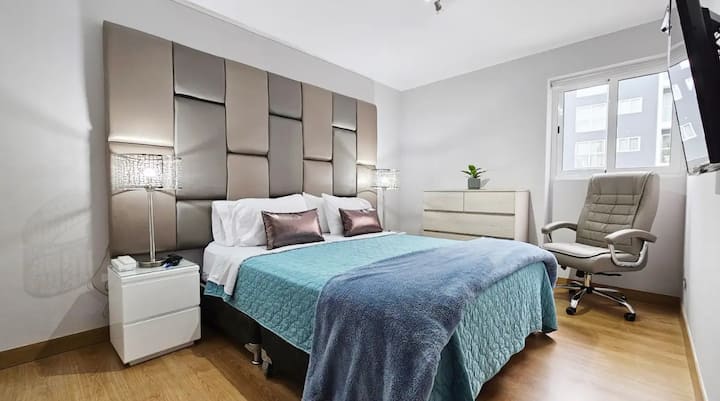 Dormitorio cama queen size con veladores.