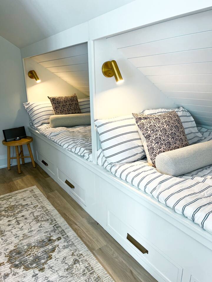 The most amazing built-in beds you'll ever see!  Two Double/Full beds with privacy and a reading light.  Shiplap on the ceiling and convenient built in drawers belong for your belongings.   Country inspired milk stools act as the side table.