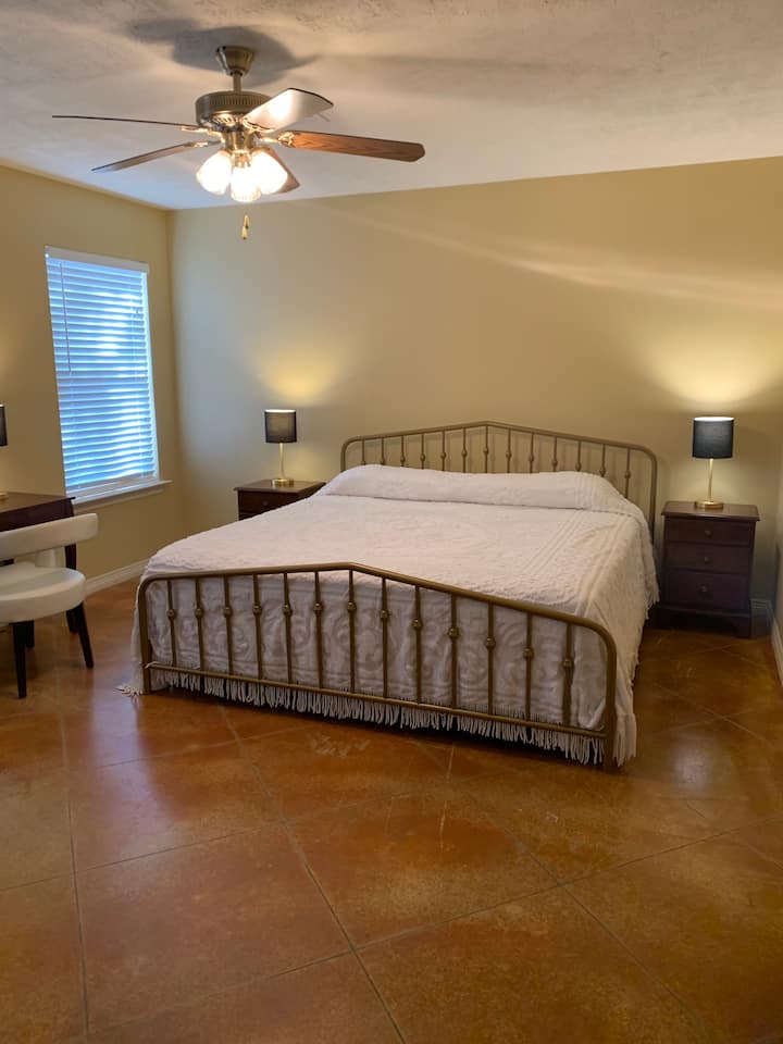 Dormitorio principal con una cama tamaño king.  ¡La nueva decoración de la pared está en camino!