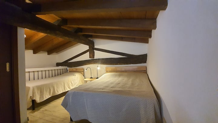 Camera da letto sul soppalco con letto singolo e letto alla francese