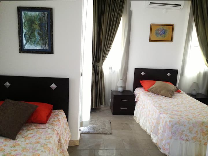 Спална соба 2 (на првиот кат) со двокреветни кревети, сопствена туш-кабина и балкон. Мермерен под, климатизиран.