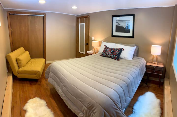 Dormitorio de nivel inferior con cama tamaño Queen y sofá cama doble convertible.