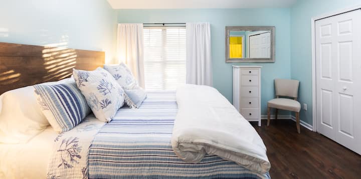 De hoofdslaapkamer heeft een kingsize bed. Matras gekocht in januari 2022 en is gewikkeld in een comfortabele matrashoes (onder hoeslaken) gewassen met elke nieuwe gast.  Enorme 43 inch Roku 4K UHD 2160P led-tv.  Wekker heeft USB-poorten.