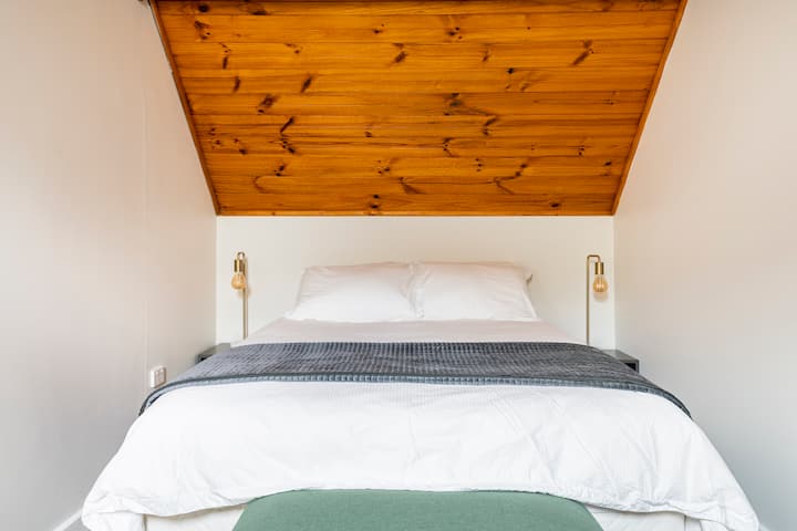 Na katu je spavaća soba s bračnim krevetom u prekrasnom potkrovlju s drvenim stropom.