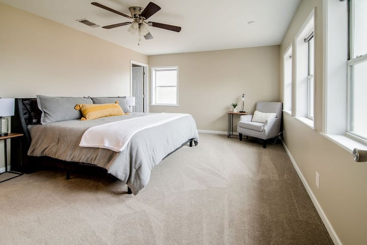 Our primary suite is spacious with abundant natural light.  It features an en suite bathroom and walk-in closet.  Windows have roller shades and black out curtains (not shown in photo).