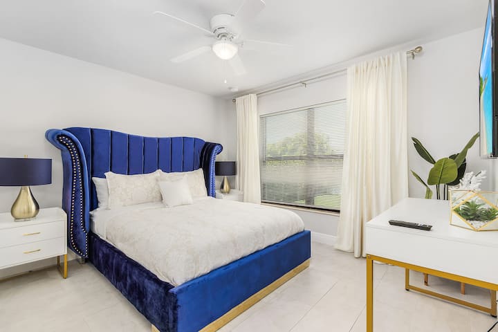 Spálňa s manželskou posteľou Queen a HD TV s výhľadom na zadný dvor. Šatníková skriňa nie je na obrázku