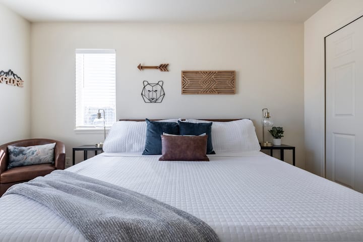 Chumba cha kulala cha dubu kina kitanda cha kifalme, kabati kubwa na kiti chenye starehe. 