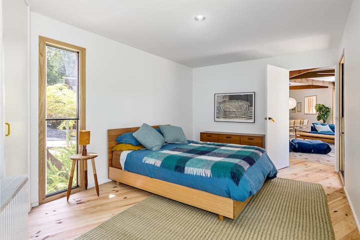 Hlavná spálňa s manželskou posteľou Queen a prechádzkou v župane a vlastnou kúpeľňou. Veľké okná rámujú lákavý výhľad. Radi sa ponoríme do nášho okolia, preto sme sa rozhodli nemať žalúzie ani záclony. Na požiadanie je možné poskytnúť rúška na oči.