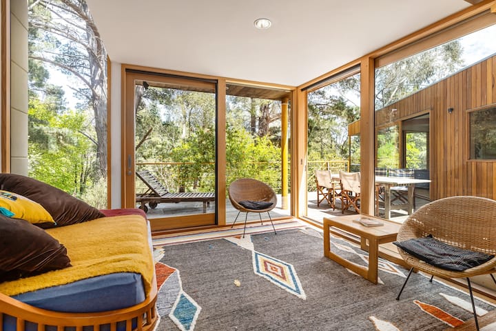 Druhý obývací priestor, ktorý sa môže zdvojnásobiť ako spálňa. Denná posteľ má luxusný matrac typu king a nádherný výhľad na okolité stromy. Radi sa ponoríme do nášho okolia, preto sme sa rozhodli nemať k dispozícii žalúzie a rúška na oči.