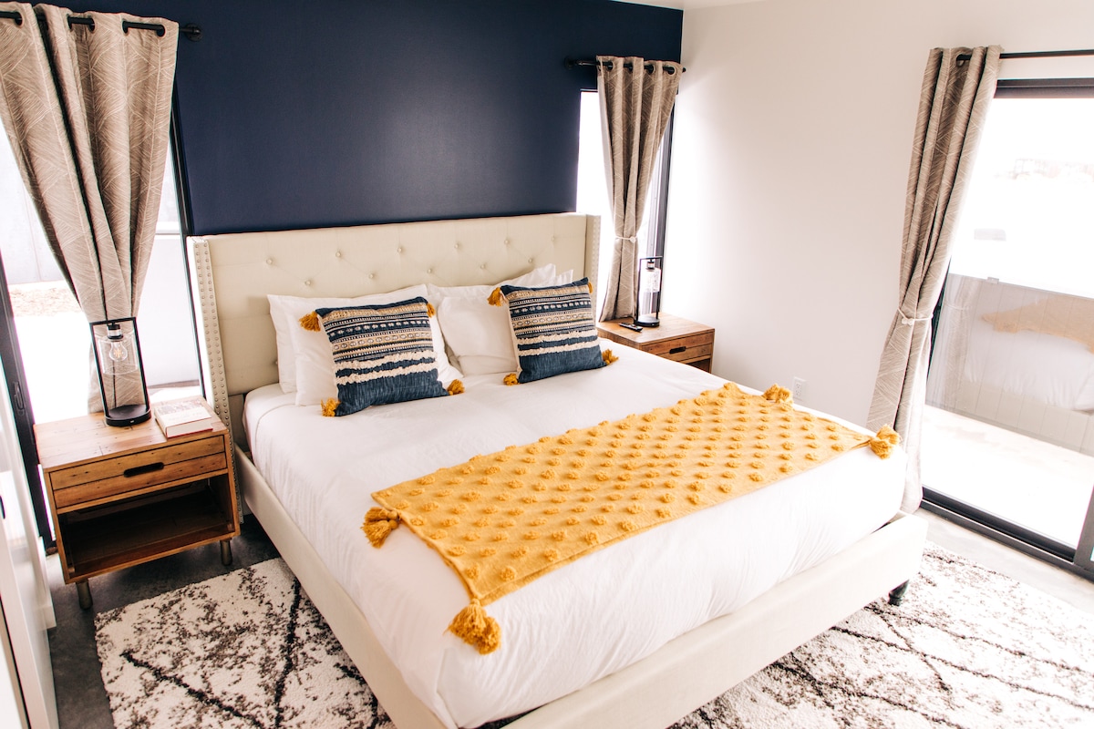 Master bedroom with King bed, wireless charging touch control lamps, black out curtains, sliding door to backyard