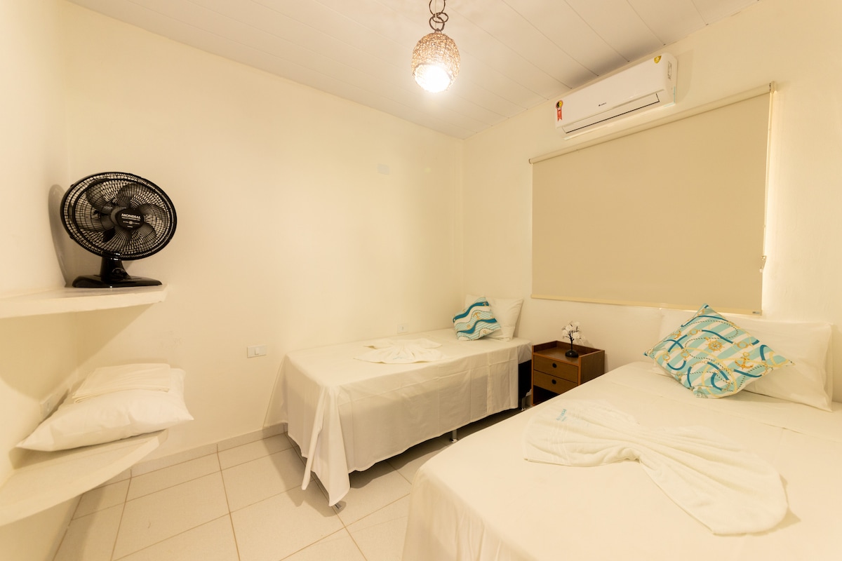 Chumba kilicho na vitanda viwili vya mtu mmoja, kiyoyozi na feni. 