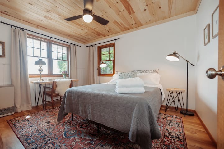 带标准双人床的卧室和湖景办公桌