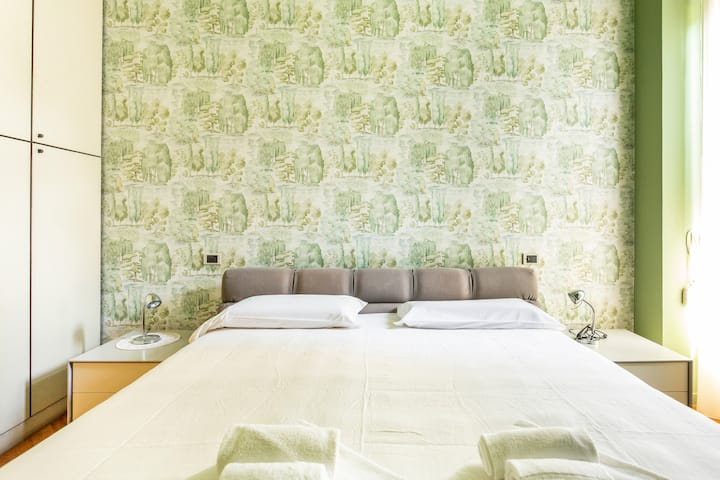 Bright bedroom with king-size bed and balcony access