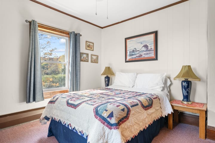 Corner upstairs bedroom with a full size bed.
