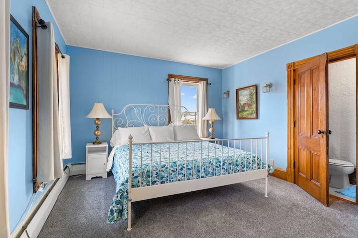 This light and airy upstairs bedroom has an ensuite half bathroom with toilet and basin.  The room is very spacious and has a king size bed.