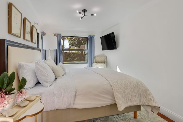 غرفة النوم الرئيسية:  بإطلالة جميلة على الفناء الأمامي ذو المناظر الطبيعية المثالية ، مع تلفزيون بشاشة كبيرة.