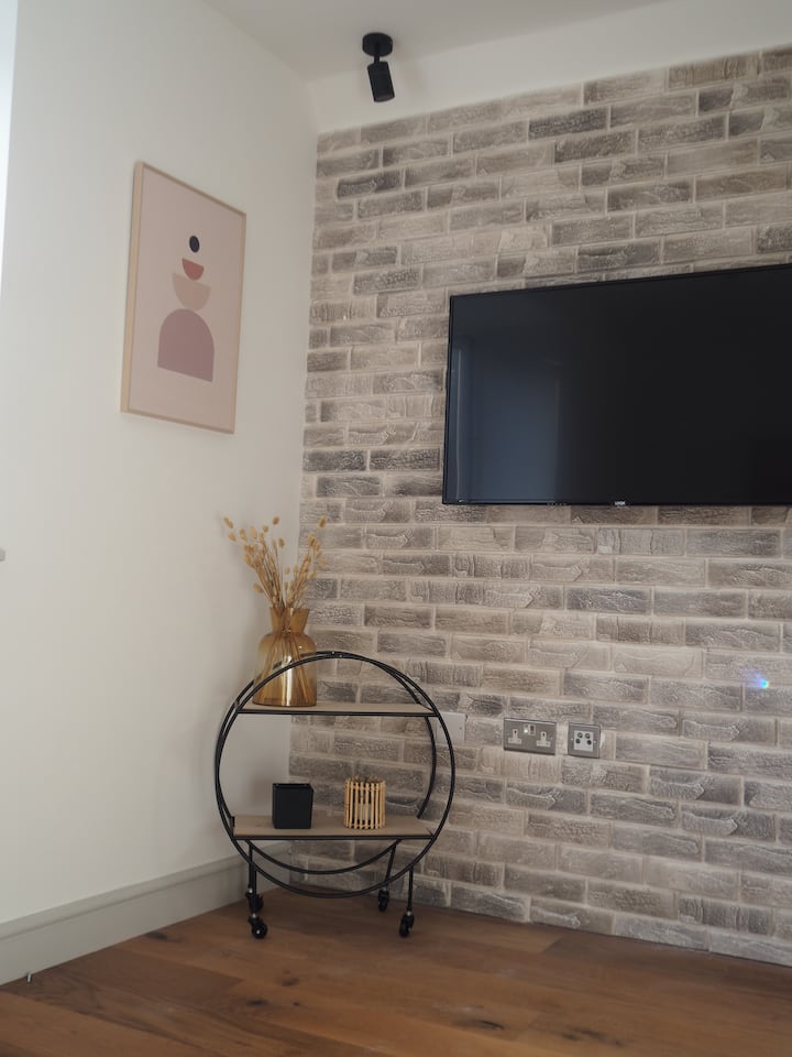 Pumzika kwenye sebule maridadi yenye kitanda cha sofa chenye ukubwa wa mara mbili, Televisheni mahiri na Wi-Fi. Sehemu hii iliyo wazi inaunganisha kwenye jiko na eneo la kula kwa urahisi zaidi.