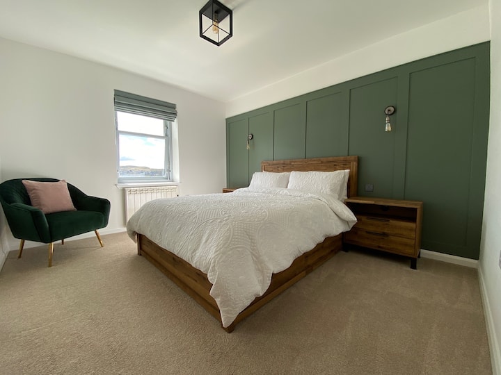Sink into comfort in our king-size bed, part of a tranquil bedroom decorated in soothing shades of white and green