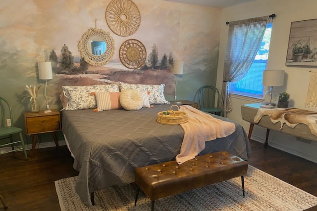 Large light and airy primary King bedroom suite w/ mid-century nightstands w/ built-in USB and plugs for charging.