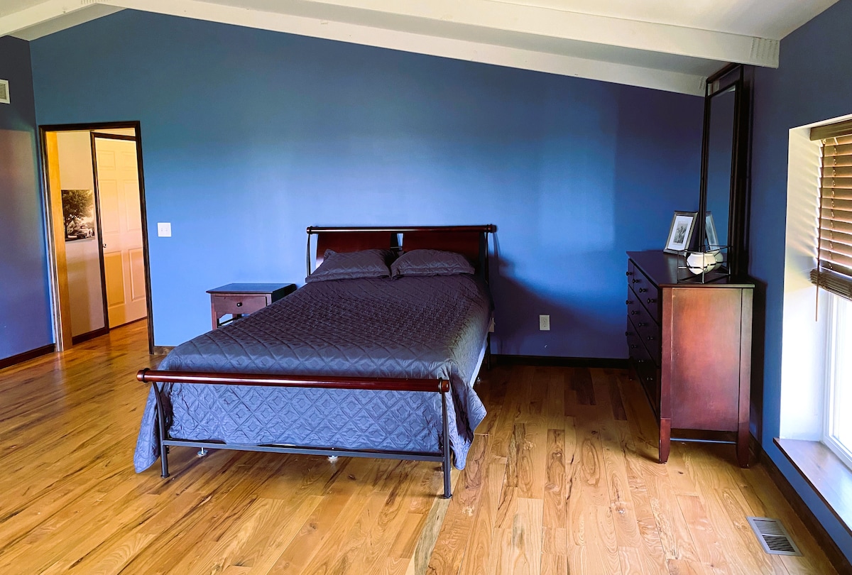 Chambre principale de 400 pieds carrés avec coin salon, salle de bain complète attenante et accès à la terrasse.