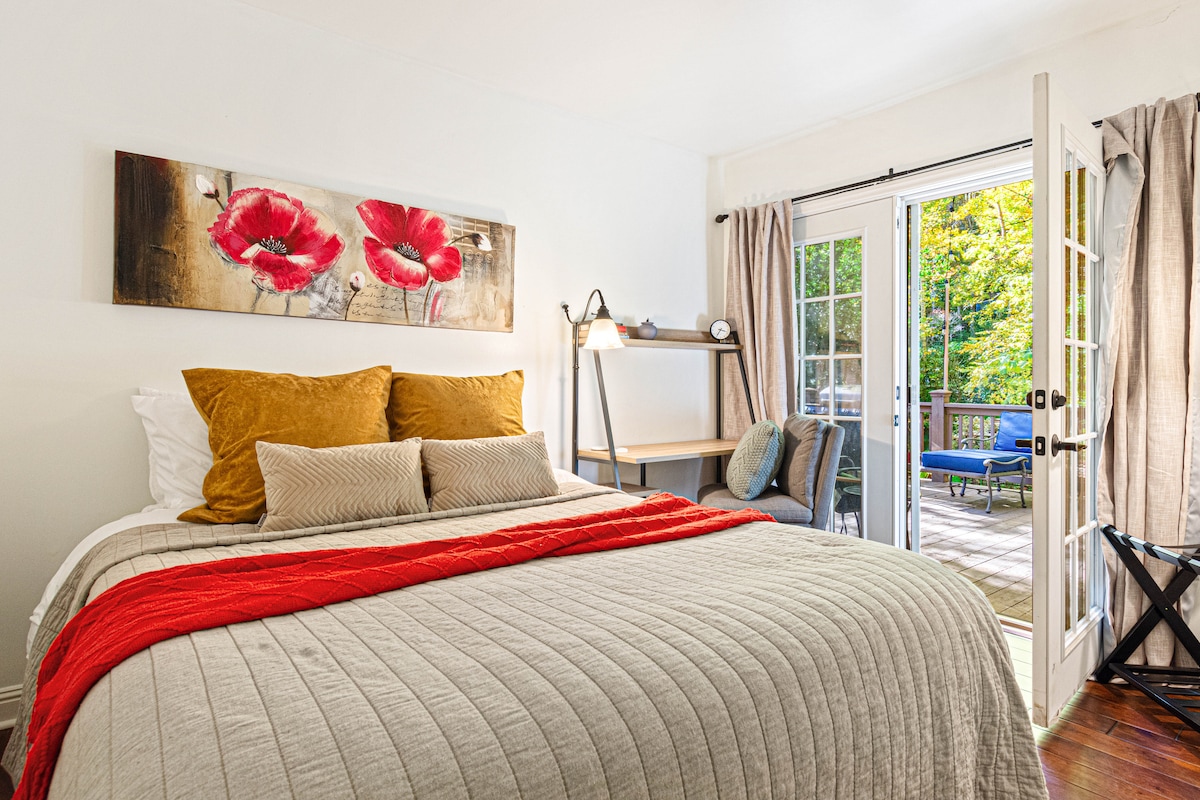 El dormitorio queen del nivel principal tiene una oficina y puertas francesas que se abren a la cubierta con parrilla y jacuzzi. Fácil acceso al estanque para sentarse y tomar tu café por la mañana y ver a los peces koi nadar. Las cortinas opacas están sobre las puertas. 