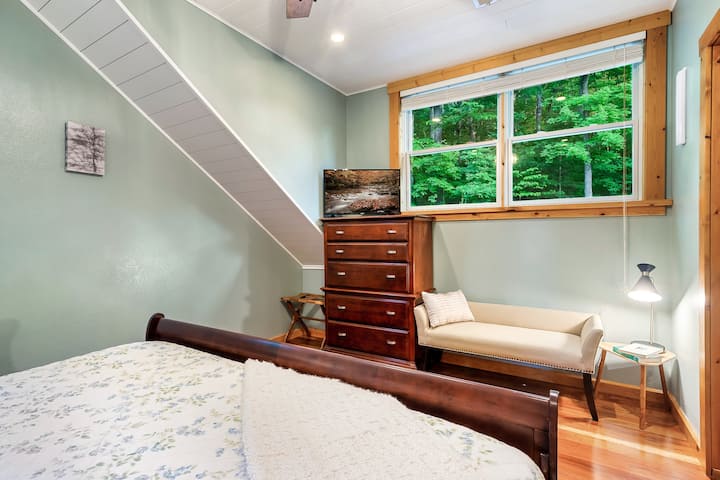 Dormitorio principal de espuma viscoelástica tamaño king en la planta superior con TV inteligente y baño privado, vestidor y un banco
