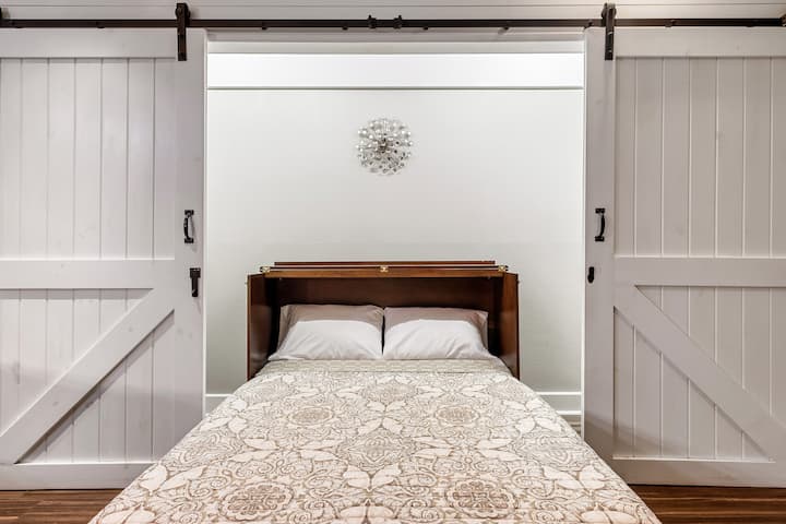 Detrás de las puertas del granero en el sótano encontrarás una súper cómoda almacenamiento de espuma viscoelástica tamaño queen cama Murphy