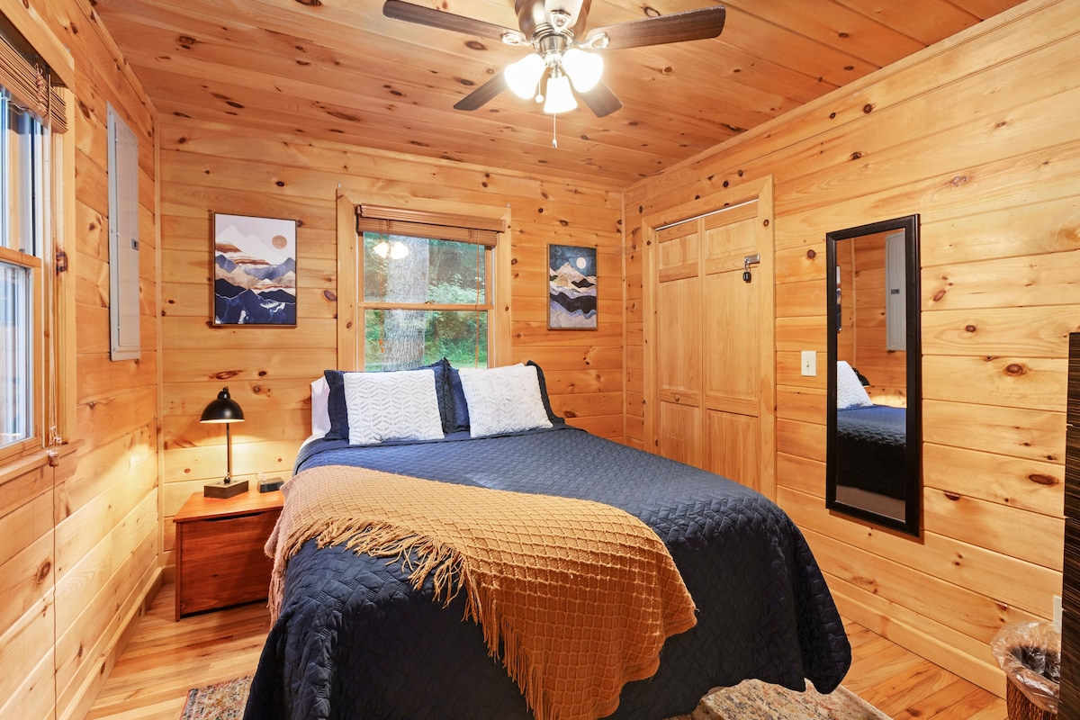 Sleep peacefully in this snug bedroom with ceiling fan, warm tones, and soft linens for a restful night’s sleep.