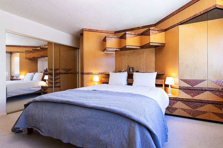 California primary bedroom with custom installed original cabinetry and closet with custom drawers.
