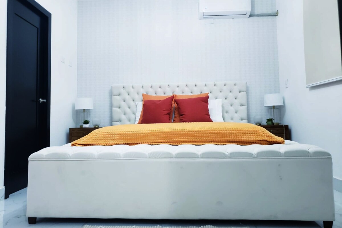 Dormitorio principal con baño privado y TV de 50 pulgadas.