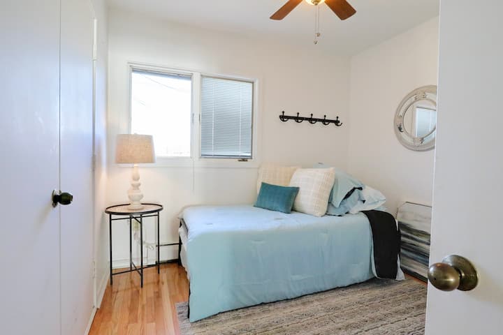 พักผ่อนอย่างสบายใจในห้องนอนที่สว่างไสว มีเตียงเดี่ยว 2 เตียง พัดลมเพดาน และการตกแต่งที่ทันสมัย เหมาะสำหรับเด็ก เพื่อน หรือนักเดินทางคนเดียวที่กำลังมองหาที่พักผ่อนในที่พักที่เงียบสงบและเต็มไปด้วยแสงแดด