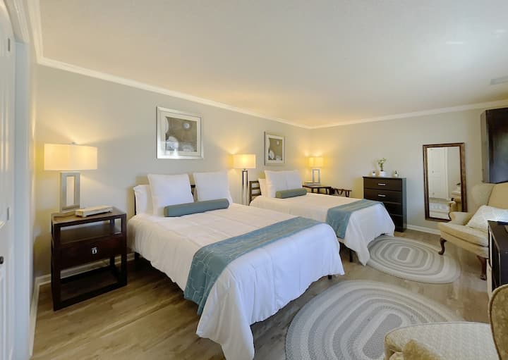 Трета просторна спалня с две двойни легла и кът за сядане за отдих преди лягане. 